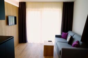 a living room with a couch and a large window at Residence Larciunei in Ortisei