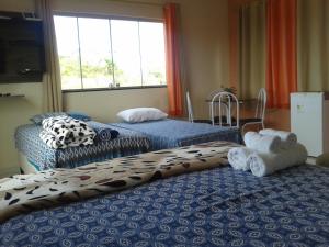 a room with two beds and a window at Sobre as Pedras Chalés in Monte das Gameleiras