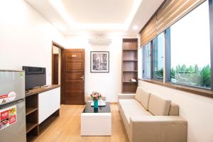 a living room with a couch and a tv at Canary Ha Noi Hotel in Hanoi