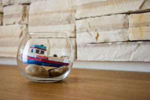 a glass bowl with a boat in it on a table at Villa Rooms Mediteran in Borovići