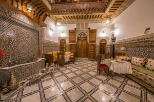 a room with a table and chairs in a building at Riad Ouliya in Fez