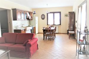 sala de estar con sofá y cocina con mesa en Agriturismo Colle d' Oro, en Pescia Romana