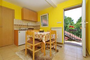 a kitchen with a table and chairs and a kitchen with yellow walls at Apartments Junior in Zlatibor