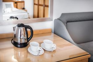 a tea kettle and two cups on a table at Hotel Bellavista in Lignano Sabbiadoro