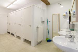 ein Badezimmer mit 3 Waschbecken und weißen Schränken in der Unterkunft Albergue Valderrobres Auto check-in in Valderrobres
