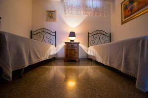 カストロ・ディ・レッチェにあるVilla Scicchiのベッドルーム1室(ベッド2台、テーブルの上にランプ付)