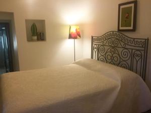 - une chambre avec un lit blanc et une lampe dans l'établissement Trulli Paparale, à Alberobello