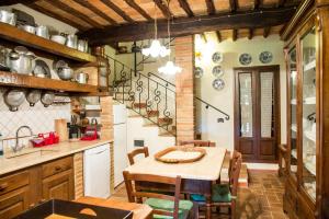a kitchen with a table, chairs and a stove at Borgo alle Mura in Casale Marittimo