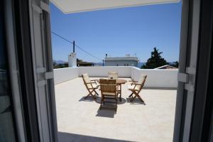 un patio con mesa y sillas en la azotea en Peskesi Ikaria en Agios Kirykos