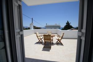 a patio with a table and chairs on a roof at Peskesi Ikaria in Agios Kirykos