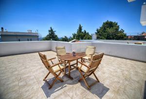einen Tisch und vier Stühle auf dem Dach in der Unterkunft Peskesi Ikaria in Agios Kirykos