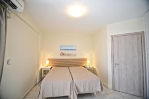 een slaapkamer met een bed met een witte sprei bij Peskesi Ikaria in Agios Kirykos