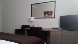 a bedroom with a desk with a television and a bed at Studia Letců 2A in Olomouc