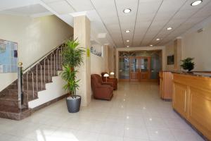 an office lobby with a staircase and chairs and a stair case at Hotel Pantón in Vigo