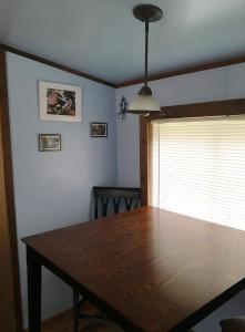 a dining room with a wooden table and a window at Hollis Creek Cabin in Hollis