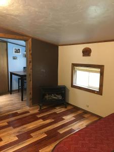 a living room with a fireplace and a table at Hollis Creek Cabin in Hollis