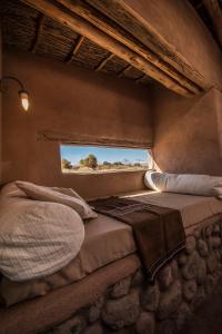 een slaapkamer met 2 bedden in een kamer met een raam bij Casa Chincol in San Pedro de Atacama