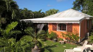 ein kleines Haus mit einer Palme davor in der Unterkunft Cap Martinique in Sainte-Anne