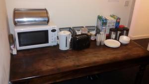 a microwave sitting on top of a wooden table at Budget Hostel in Newcastle upon Tyne