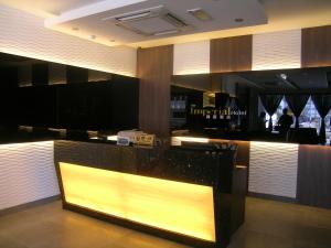 a restaurant with a bar with a yellow sign at The Imperial Hotel in Kluang