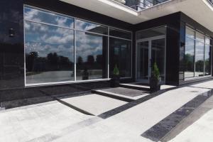a building with large glass windows and a patio at Zinedine Sport-Hotel in Uzhhorod