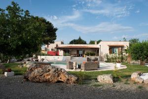 een huis met een grote rots voor een tuin bij Villa Franca in Noci