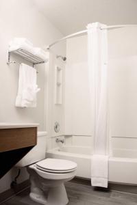 y baño blanco con aseo y ducha. en Super 8 by Wyndham Juneau en Juneau