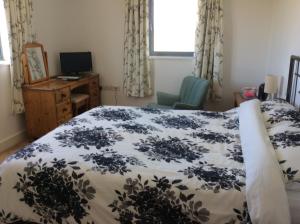 a bedroom with a bed and a desk and a window at HH Accommodation in Millom