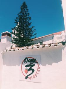 a sign on a wall with a tree in the background at Orange3 Hostel in Lagos