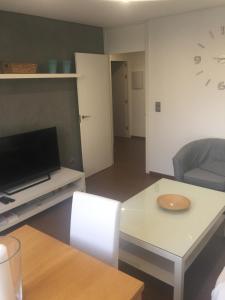 sala de estar con TV y mesa en Boulevard Suite Cordoba en Córdoba