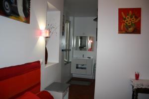 a living room with a red couch and a sink at Mas de Bellegou in Portiragnes