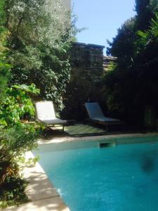 une piscine avec deux chaises longues et une piscine dans l'établissement Rose-INN appartement, à Orange