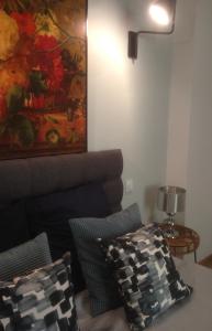 a living room with a painting on the wall and pillows at Rose-INN appartement in Orange