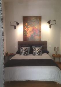 オランジュにあるRose-INN appartementのベッドルーム1室(壁に絵画が描かれたベッド1台付)