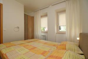 a bedroom with a bed and two windows at Lux Apartment Lazarevic in Zlatibor