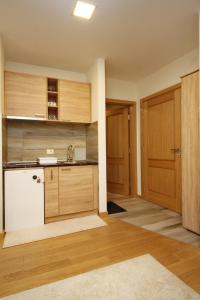 a kitchen with wooden cabinets and a white refrigerator at Lux Apartment Lazarevic in Zlatibor +7 photos