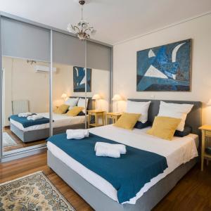 a bedroom with two beds with blue and yellow pillows at Unique Flat with Sea View at Edem Beach - A Seafront Property by Athenian Homes in Athens