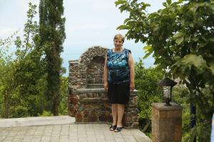a woman standing in front of a stone fountain at Mount Villa Kvariati in Kvariati