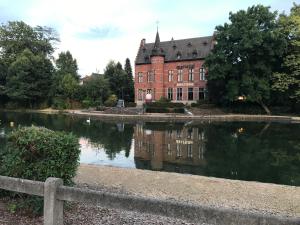 un grande edificio in mattoni con riflessione nell'acqua di Apartment Zaventem Brussels Airport J a Zaventem