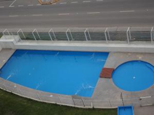 a large swimming pool with blue water in a building at Marserena in La Serena