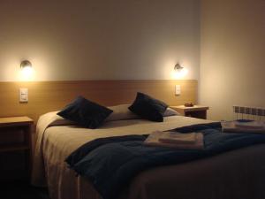 una camera con un letto e due luci sul muro di MaDiYa Departamentos a San Carlos de Bariloche