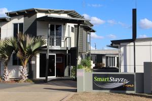a house with a large window and a large building behind it at Smart Stayzzz Inns in Clermont