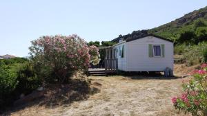 a white tiny house on a hill with flowers at La Canardiere in Casta