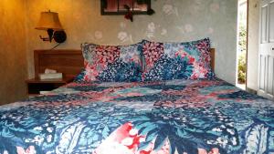 a bedroom with a bed with a blue and red comforter at Bennett Bay Inn in Coeur d'Alene