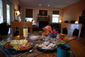 una mesa de madera con platos de comida y bebidas. en Salmon Point B&B, en Oyster Bay