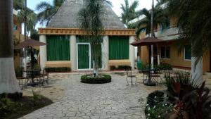 a courtyard with chairs and tables and a green building at Tecnohotel Mérida Norte in Mérida