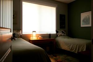 a bedroom with two beds and a window at Salmon Point B&B in Oyster Bay