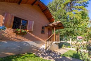 Casa con escalera de madera y porche en Casa Pau Brasil en Monte Verde