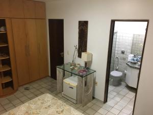 a bathroom with a glass table and a toilet at Maravilhoso Apartamento - 175 m2 in Cabedelo
