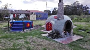 un horno al aire libre con parque infantil en un patio en Finca Saron Hostería & Spa, en Sogamoso